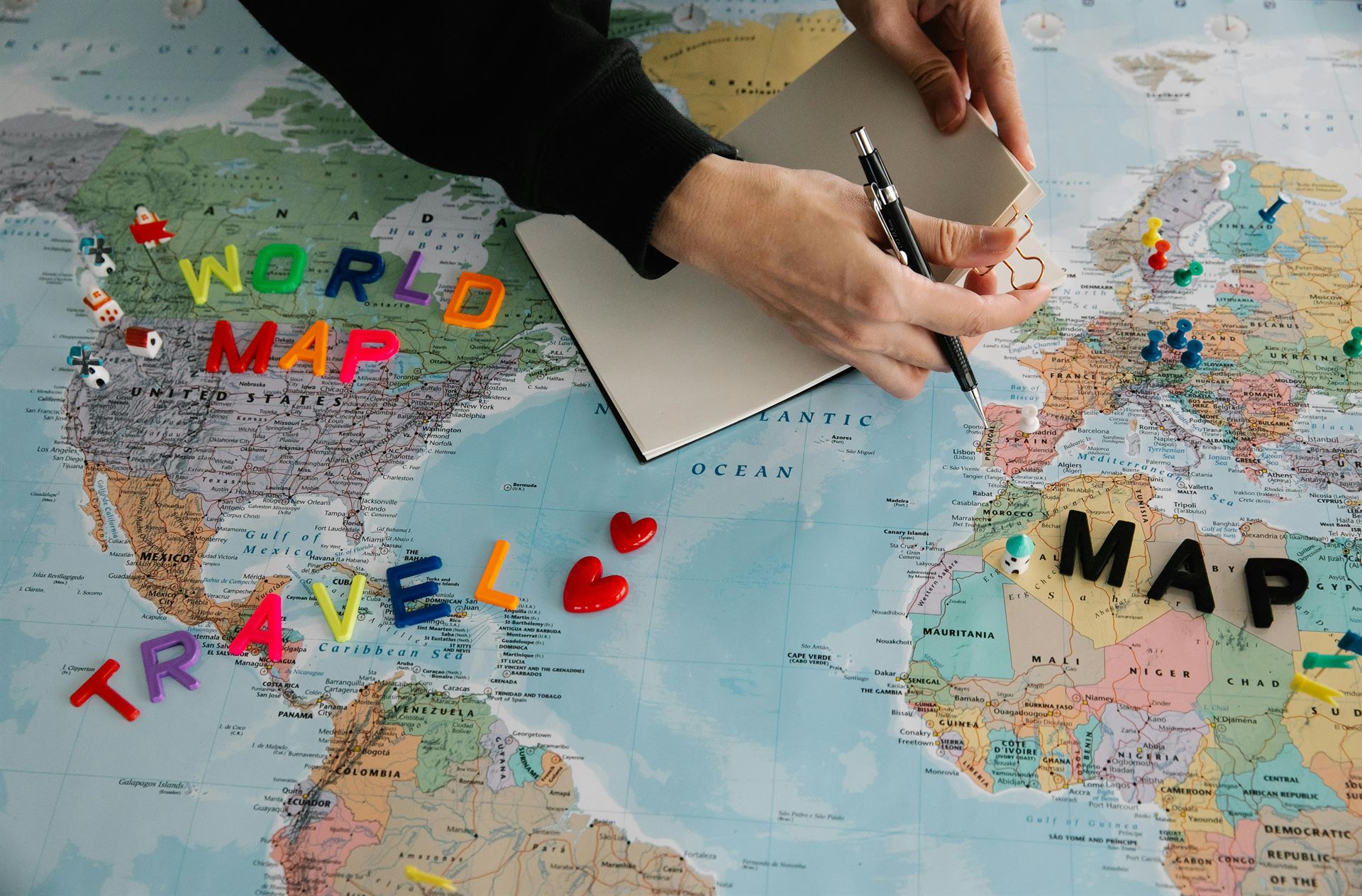 mujer-con-papel-y-boli-sobre-mapa-mundo