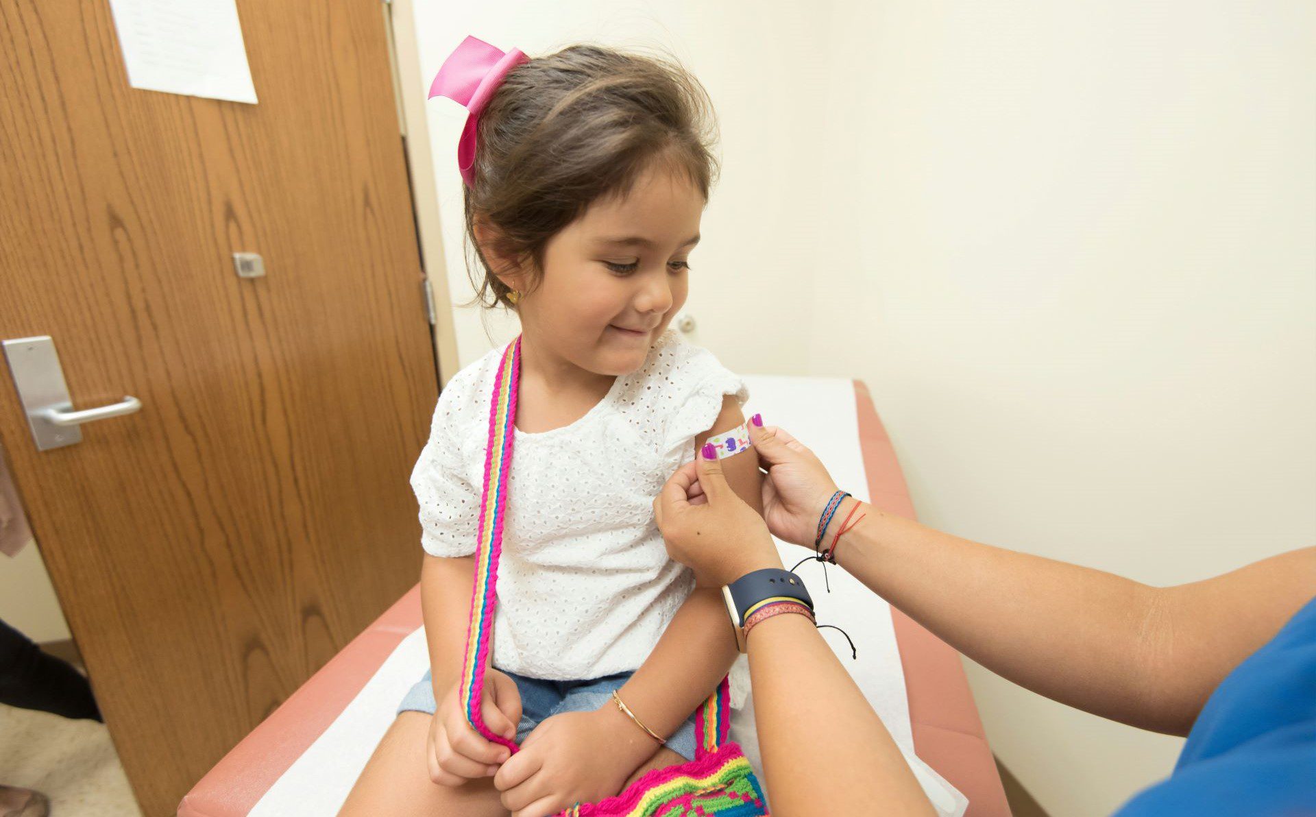 medico-coloca-tirita-en-brazo-niña